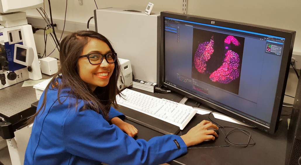 Student processing fluorescent image of data collected during independent research project.